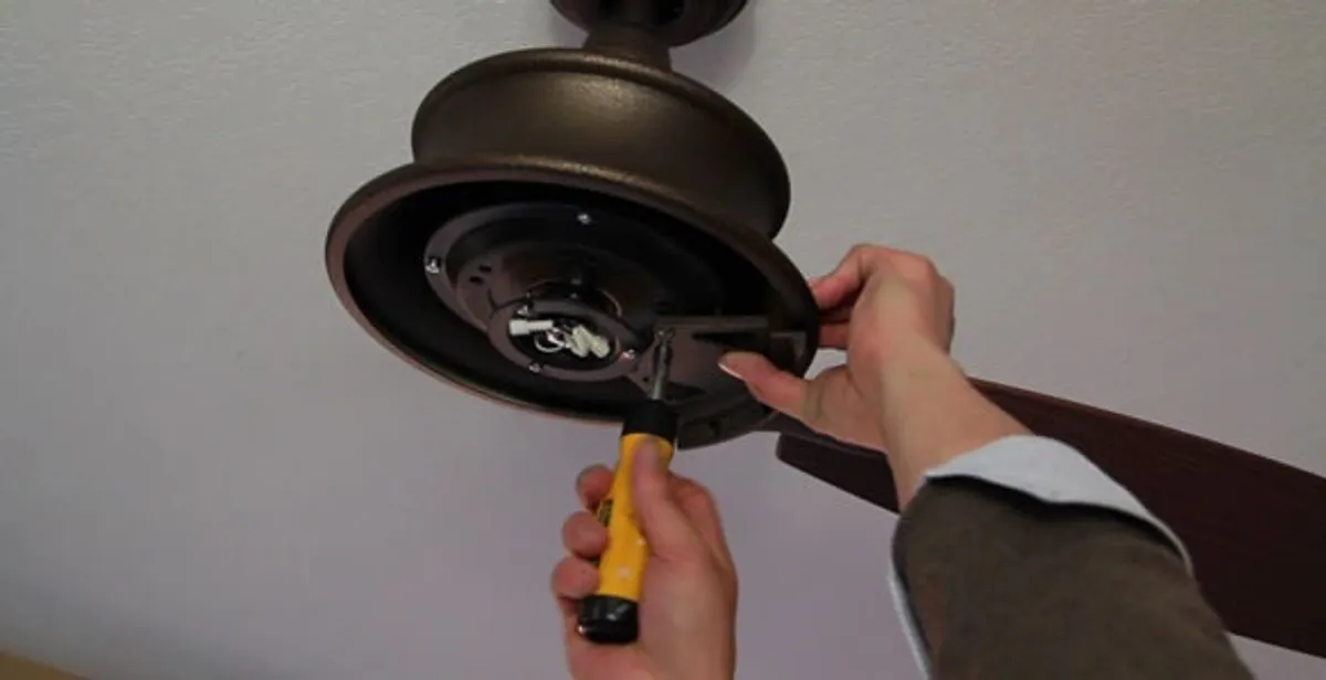 Electrician installing ceiling fan mounting bracket and fixture in Los Angeles, CA