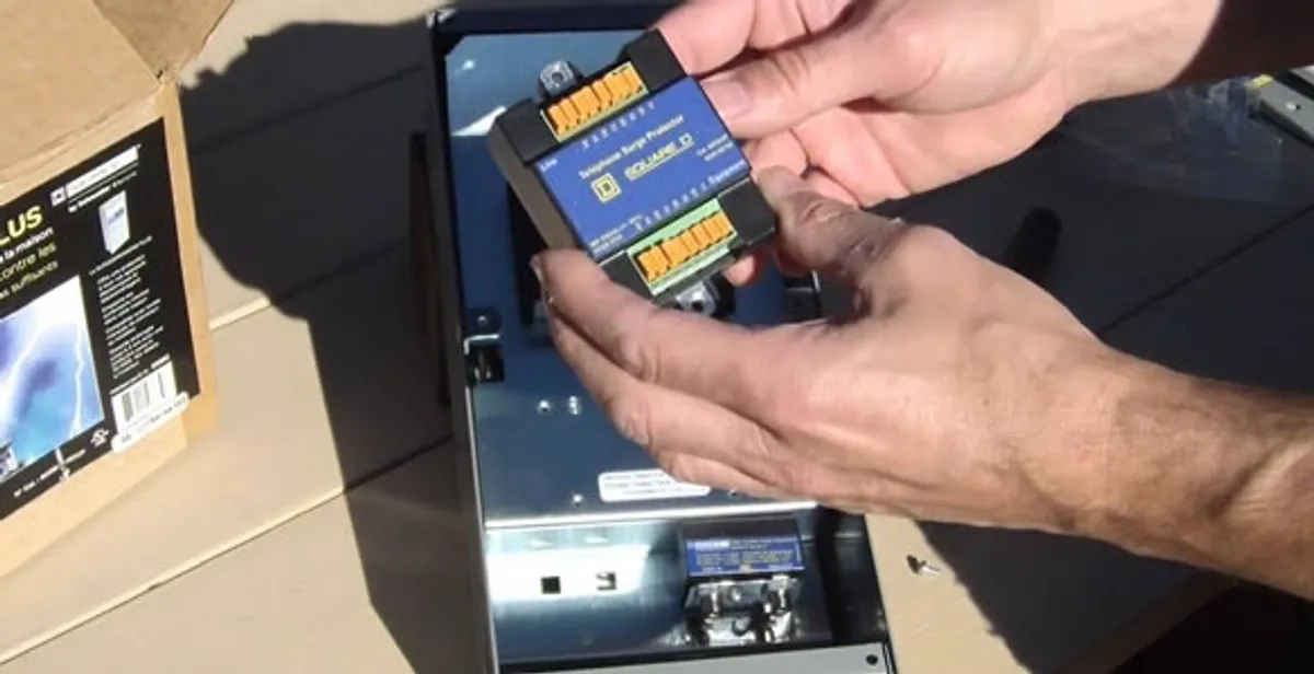 Electrician installing whole home surge protection unit inside main electrical panel in Los Angeles, CA